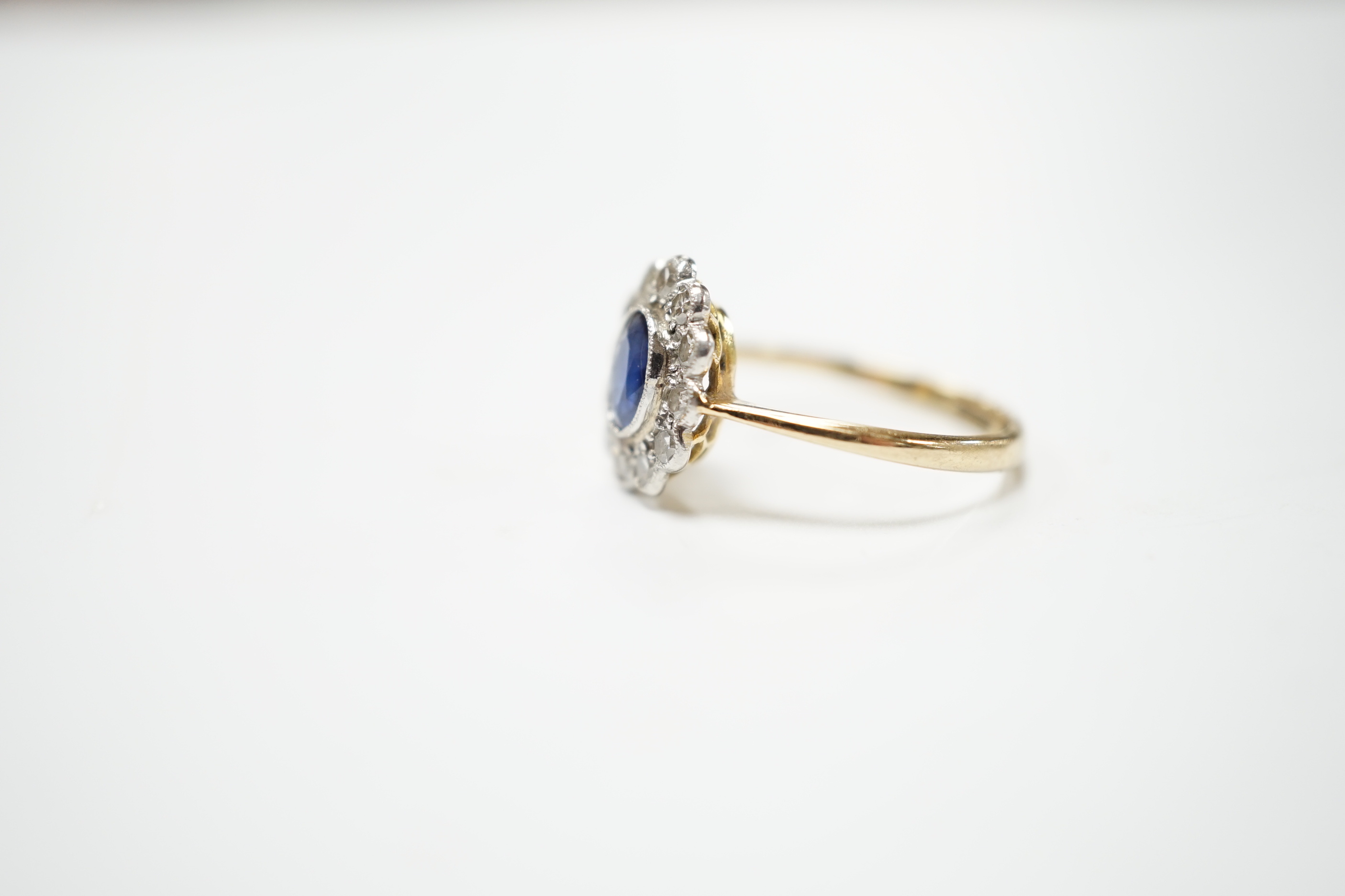 An early to mid 20th century 18ct and plat. sapphire and diamond set oval cluster ring, size L, gross weight 2.5 grams.